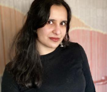 Profile picture of Nanya Jhingran wearing a black shirt and standing in front of a pink and white wall.