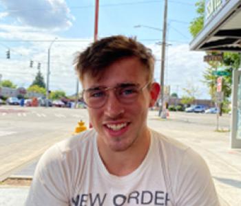 Photo of Alec Fisher in front of a palm tree.