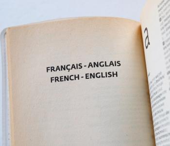 Close up picture of a book page that reads French-English in both French and English.