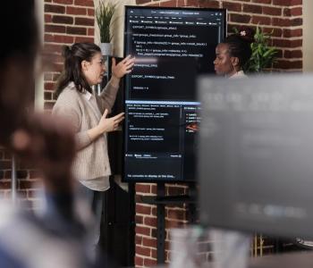 two developers collaborating on a vertical, shared screen