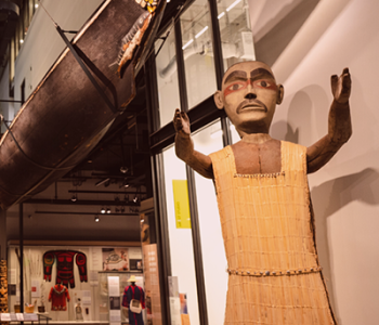 Welcome figure and canoe positioned in Burke Museum's Northwest Native Art gallery.