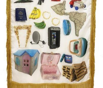 Image of silken banner/flag with golden fringe with assorted images relating to experiences of immigration from Colombia to US and diasporic Colombian life.
