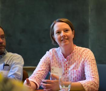 Two cohort fellows at a roundtable listening and smiling